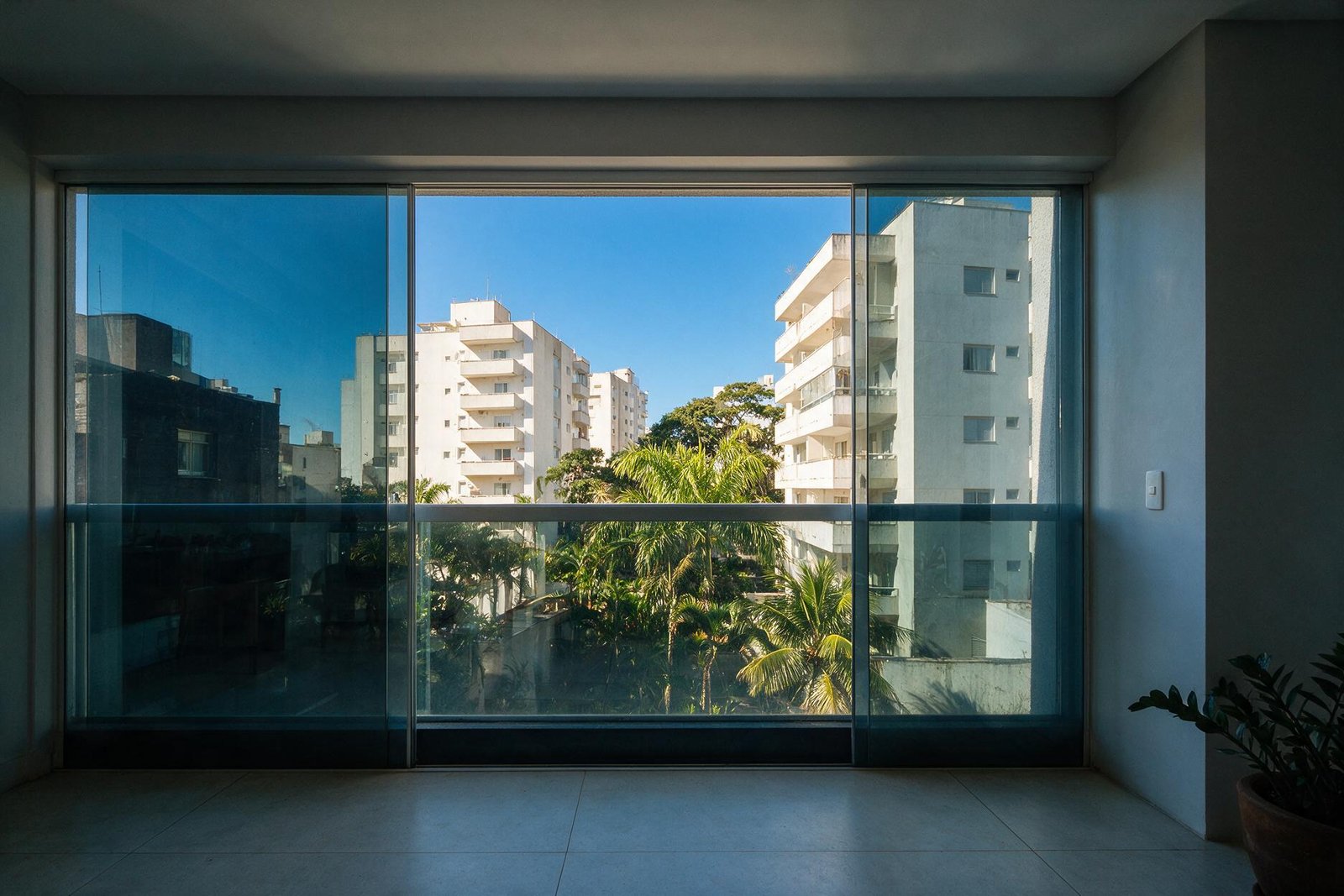Janela de correr em apartamento brasileiro com sol forte do lado de fora